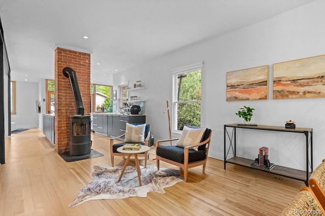 living room featuring a wood stove, light wood-style floors, plenty of natural light, and recessed lighting