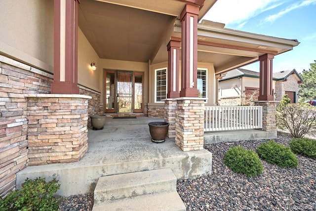 entrance to property featuring covered porch and stone siding