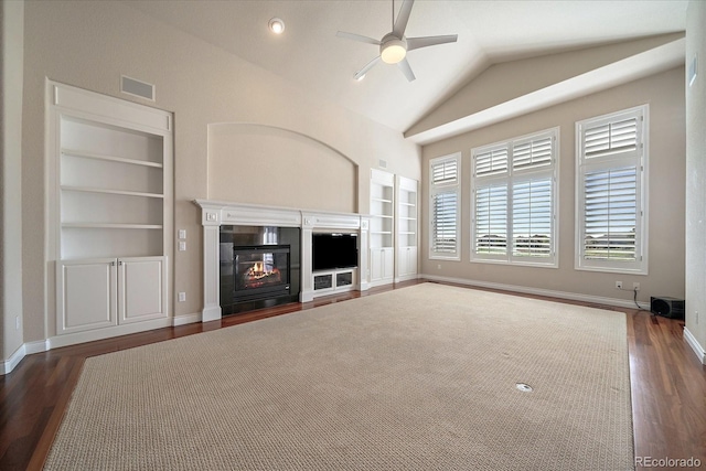 unfurnished living room with a glass covered fireplace, wood finished floors, ceiling fan, built in shelves, and vaulted ceiling