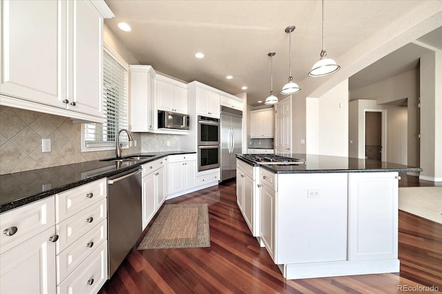 kitchen featuring a kitchen island, dark wood-style flooring, appliances with stainless steel finishes, and a sink