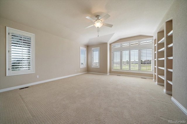 unfurnished room with visible vents, baseboards, a ceiling fan, carpet, and vaulted ceiling