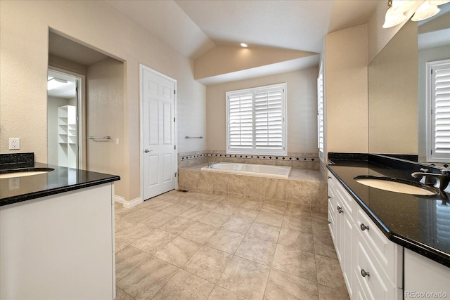 bathroom with vanity, tile patterned flooring, a bath, and lofted ceiling