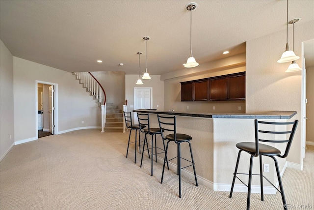 kitchen with a kitchen breakfast bar and light carpet