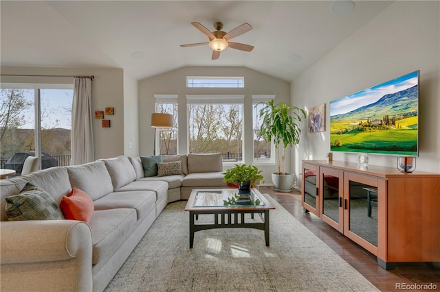 living area featuring vaulted ceiling, dark wood finished floors, and ceiling fan