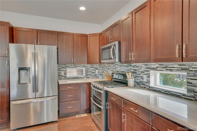 kitchen featuring light countertops, appliances with stainless steel finishes, and decorative backsplash