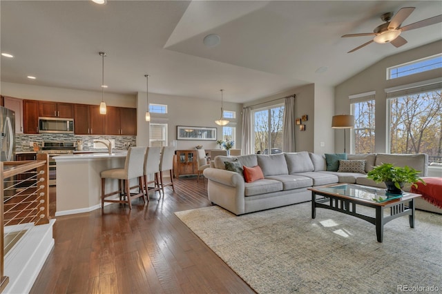 living area featuring vaulted ceiling, dark wood finished floors, a ceiling fan, and recessed lighting