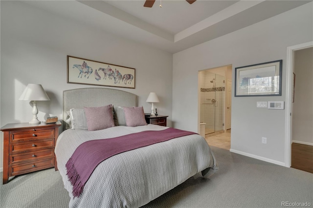 bedroom with light carpet, baseboards, a raised ceiling, connected bathroom, and ceiling fan