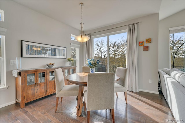 dining space featuring dark wood-type flooring and baseboards