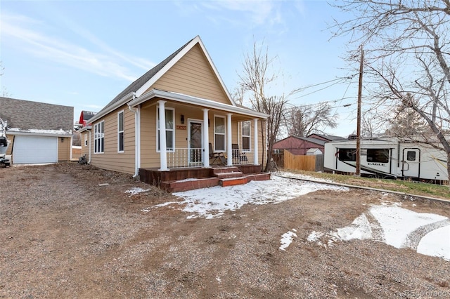 view of front of home with a garage, an outdoor structure, and a porch