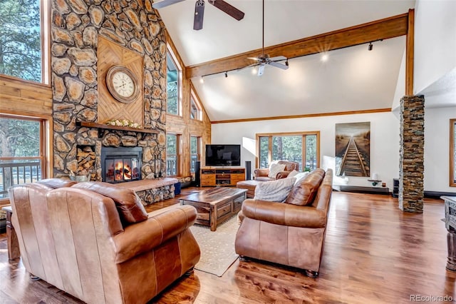 living room featuring wood-type flooring, a fireplace, high vaulted ceiling, and beamed ceiling