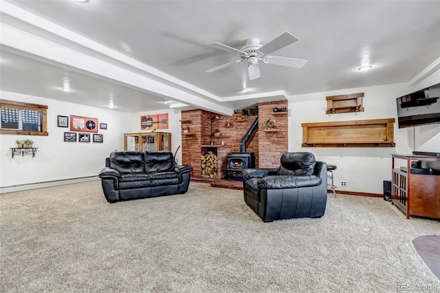 carpeted living room with a baseboard radiator, a wood stove, and ceiling fan