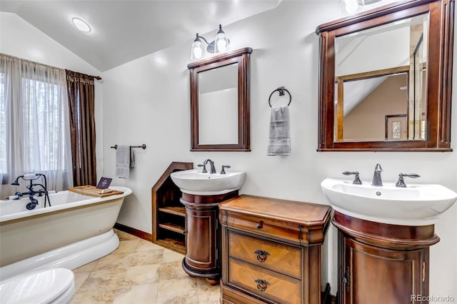 bathroom with a tub to relax in, lofted ceiling, and sink