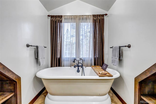 bathroom with vaulted ceiling and a washtub