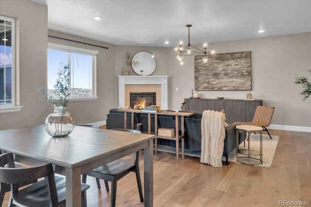 1721 Wingfeather Ln, Castle Rock, CO 80108 - dining room featuring a fireplace, wood finished floors, recessed lighting, and a chandelier