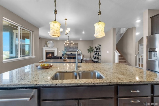 1721 Wingfeather Ln, Castle Rock, CO 80108 - kitchen with open floor plan, dark brown cabinets, stainless steel appliances, a center island with sink, and decorative light fixtures
