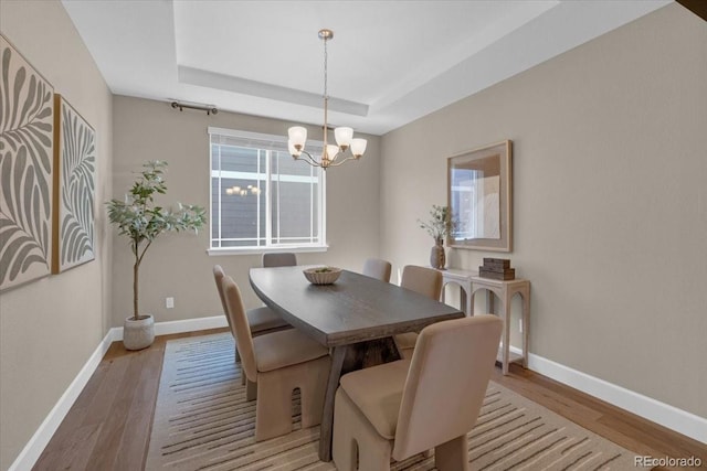 1721 Wingfeather Ln, Castle Rock, CO 80108 - dining area with wood finished floors, a chandelier, and a raised ceiling