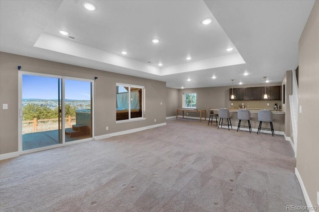 1721 Wingfeather Ln, Castle Rock, CO 80108 - living area featuring a tray ceiling, light carpet, and recessed lighting