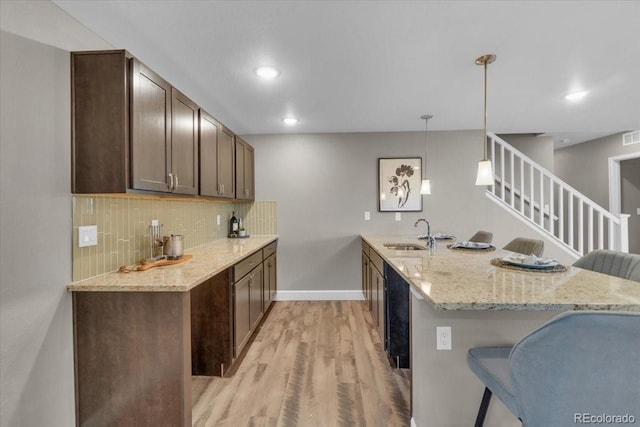1721 Wingfeather Ln, Castle Rock, CO 80108 - kitchen with a peninsula, light wood finished floors, a breakfast bar, tasteful backsplash, and recessed lighting