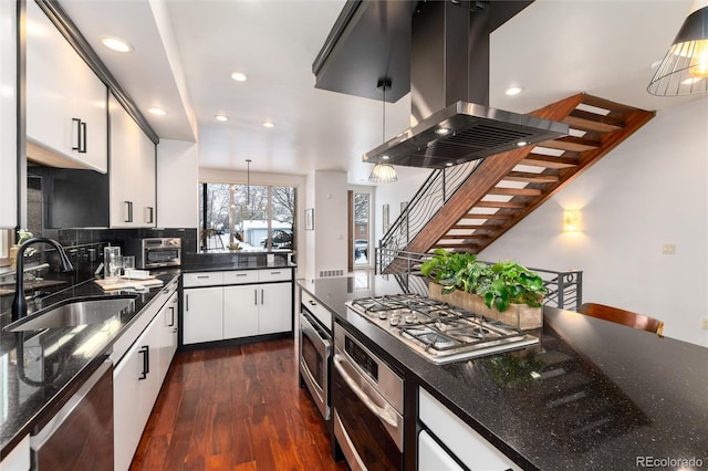 kitchen featuring island exhaust hood, decorative light fixtures, white cabinets, and sink