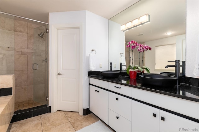 bathroom featuring tile patterned flooring, vanity, and a shower with door