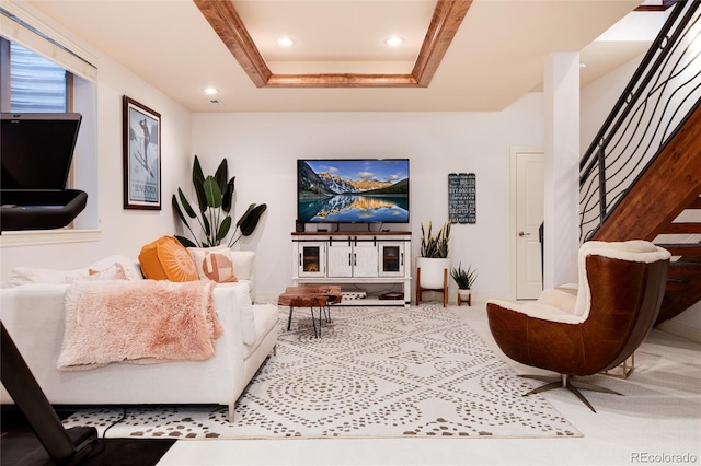 living room featuring carpet floors and a tray ceiling