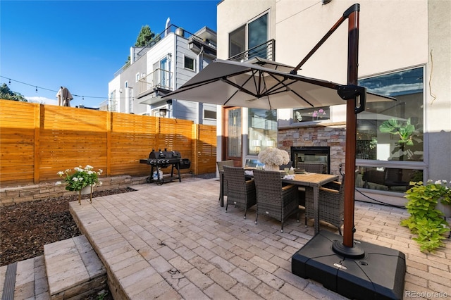 view of patio / terrace featuring an outdoor stone fireplace and grilling area