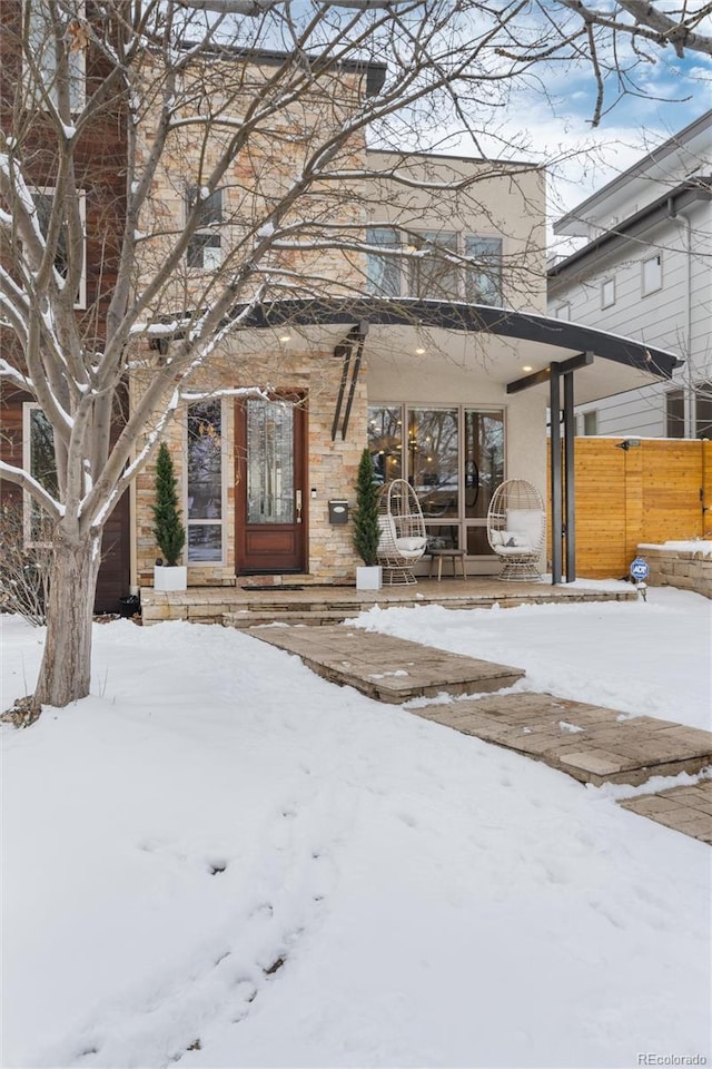 snow covered property entrance with covered porch