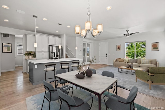 17970 E 106th Pl, Commerce City, CO 80022 - dining space featuring recessed lighting, a chandelier, light wood-style floors, a ceiling fan, and stairs