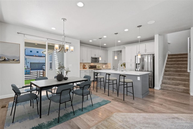 17970 E 106th Pl, Commerce City, CO 80022 - dining area with a chandelier, recessed lighting, stairs, and light wood-type flooring