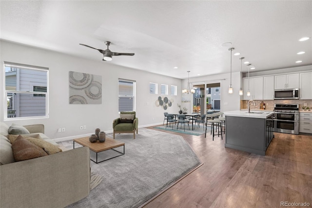 17970 E 106th Pl, Commerce City, CO 80022 - living area with a ceiling fan, recessed lighting, wood finished floors, and a chandelier