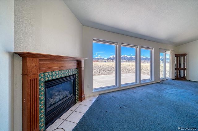 unfurnished living room featuring light carpet, a tile fireplace, and a textured ceiling