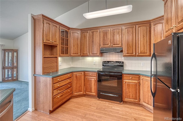 kitchen featuring lofted ceiling, decorative backsplash, light wood-type flooring, and black appliances