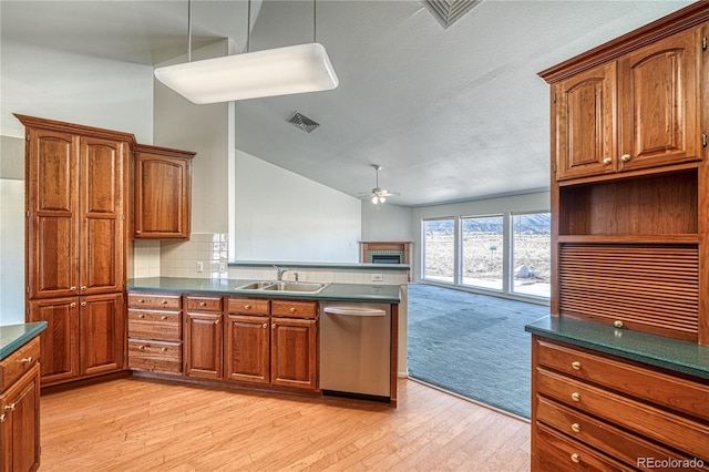 kitchen featuring vaulted ceiling, sink, stainless steel dishwasher, ceiling fan, and light hardwood / wood-style flooring