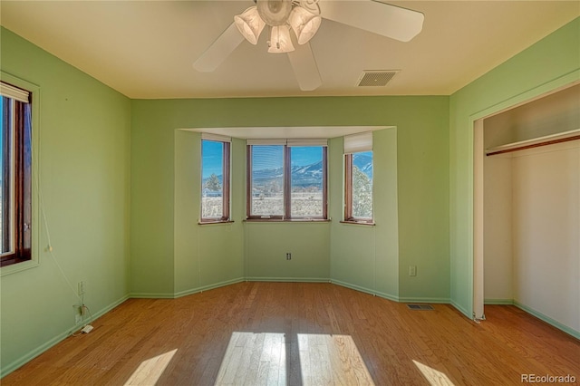 unfurnished bedroom with ceiling fan, light hardwood / wood-style floors, and a closet