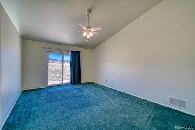 unfurnished room featuring dark colored carpet, vaulted ceiling, and ceiling fan