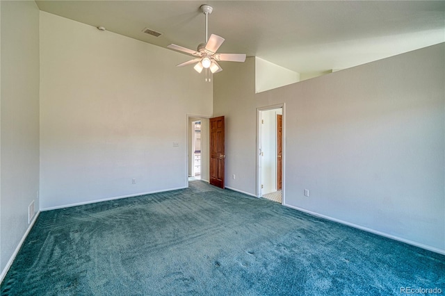 spare room with dark colored carpet, high vaulted ceiling, and ceiling fan