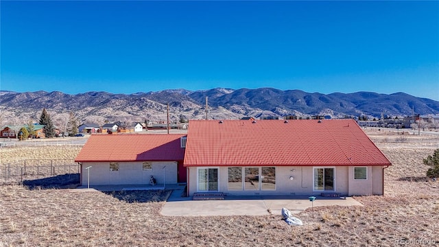 rear view of property with a mountain view and a patio