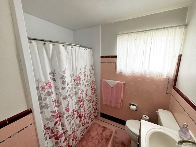 bathroom featuring sink, tile walls, a shower with shower curtain, tile patterned floors, and toilet