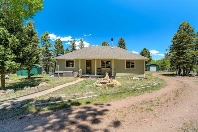 view of front of home featuring a porch, a garage, and an outdoor structure