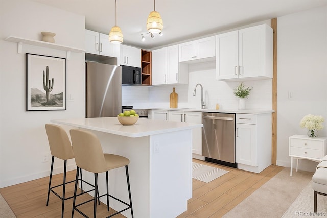 29656 Buffalo Park Rd Unit 208, Evergreen, CO 80439 - kitchen with stainless steel appliances, open shelves, decorative backsplash, a kitchen breakfast bar, and light wood finished floors