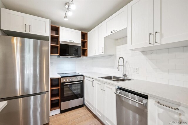 29656 Buffalo Park Rd Unit 208, Evergreen, CO 80439 - kitchen featuring stainless steel appliances, open shelves, white cabinetry, light wood finished floors, and tasteful backsplash