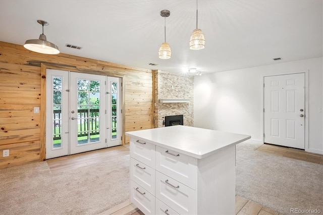 29656 Buffalo Park Rd Unit 208, Evergreen, CO 80439 - kitchen featuring wood walls, light colored carpet, white cabinets, open floor plan, and a center island