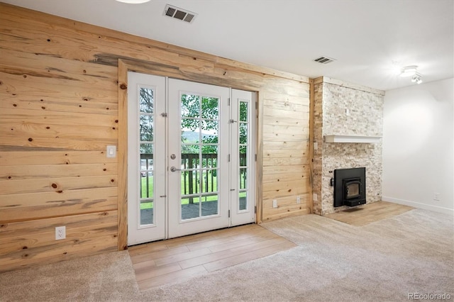 29656 Buffalo Park Rd Unit 208, Evergreen, CO 80439 - doorway with wooden walls, carpet flooring, and a wood stove