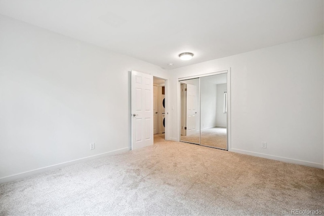 29656 Buffalo Park Rd Unit 208, Evergreen, CO 80439 - unfurnished bedroom featuring estacked washer and dryer, light carpet, and a closet