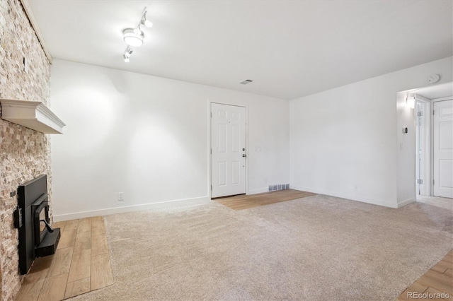 29656 Buffalo Park Rd Unit 208, Evergreen, CO 80439 - unfurnished living room with light wood-style flooring and a wood stove