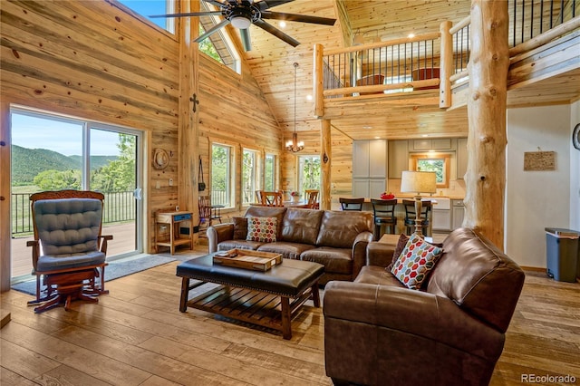 2474 Wendt Ln, Fort Garland, CO 81133 - living area featuring high vaulted ceiling, light wood finished floors, a ceiling fan, a chandelier, and wooden walls