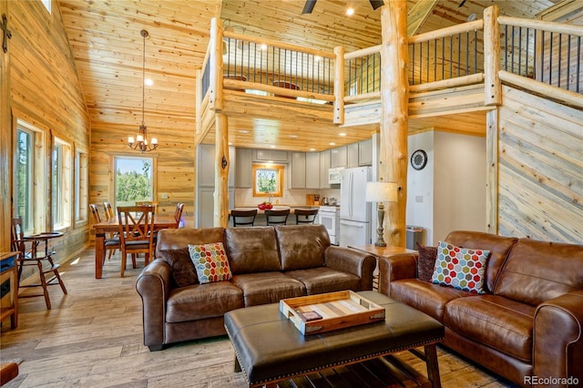 2474 Wendt Ln, Fort Garland, CO 81133 - living room with high vaulted ceiling, light wood-type flooring, a chandelier, wooden ceiling, and wooden walls