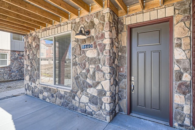 doorway to property featuring stone siding