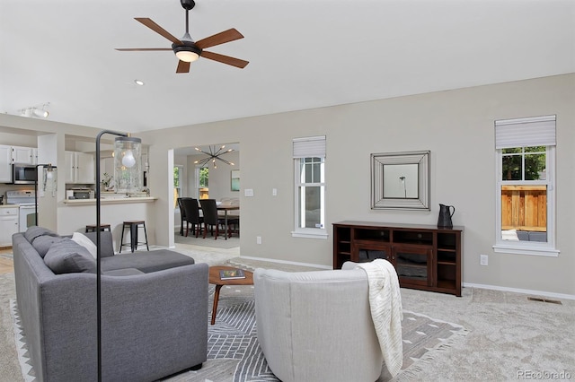 690 W Jamison Cir, Littleton, CO 80120 - living room featuring a ceiling fan, plenty of natural light, light colored carpet, and baseboards