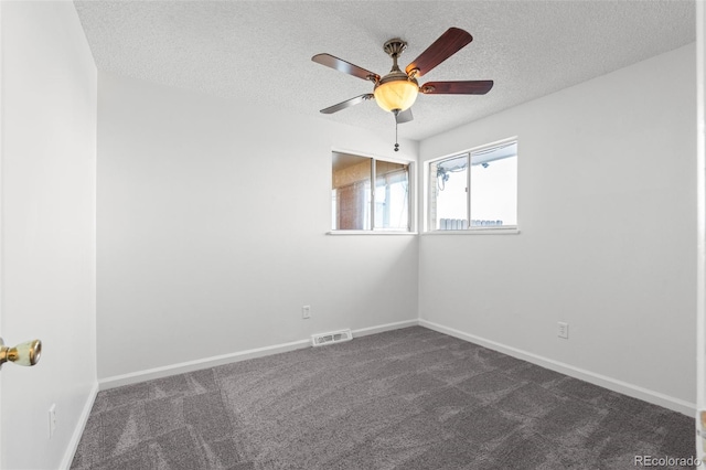 unfurnished room featuring dark colored carpet, ceiling fan, and a textured ceiling